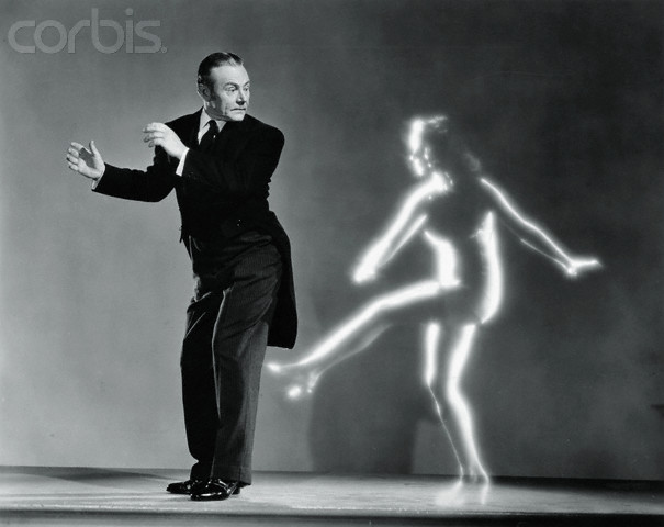 ca. 1940 --- The invisible woman Kitty Carroll (Virginia Bruce) kicks George (Charles Ruggles) from behind in the 1940 film The Invisible Woman. --- Image by © John Springer Collection/CORBIS